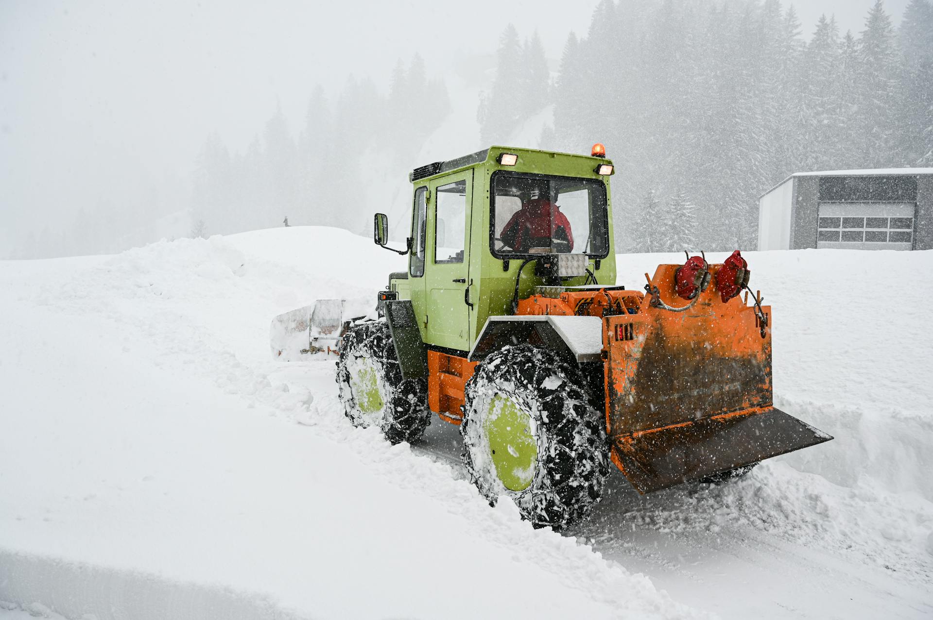Green and Orange Snow Tractor on Snow Covered Ground