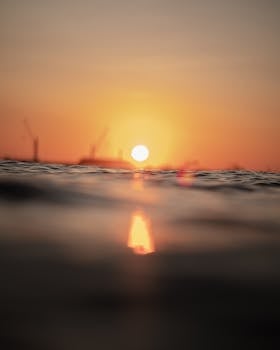 Capture the serene beauty of a sunset over the sea with a city silhouette in Arica, Chile.