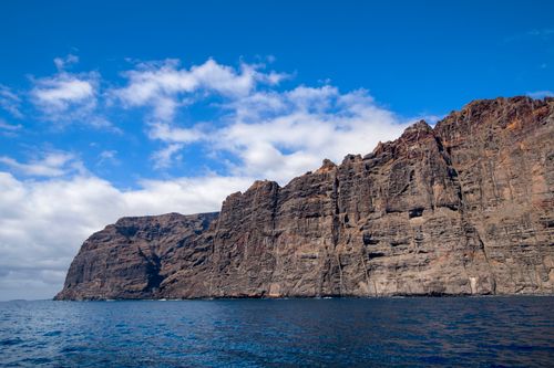 Free Stunning coastal cliffs rise against a clear blue sky, creating a dramatic landscape. Stock Photo