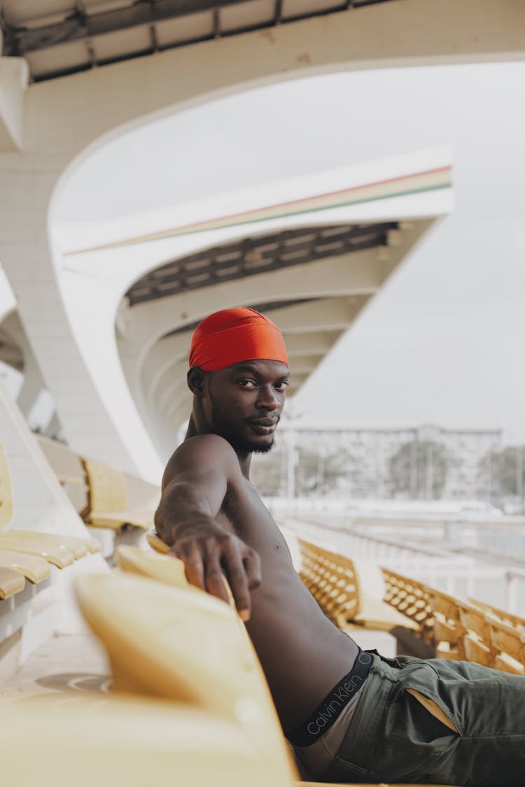 Shirtless Man Sitting On Tribune 