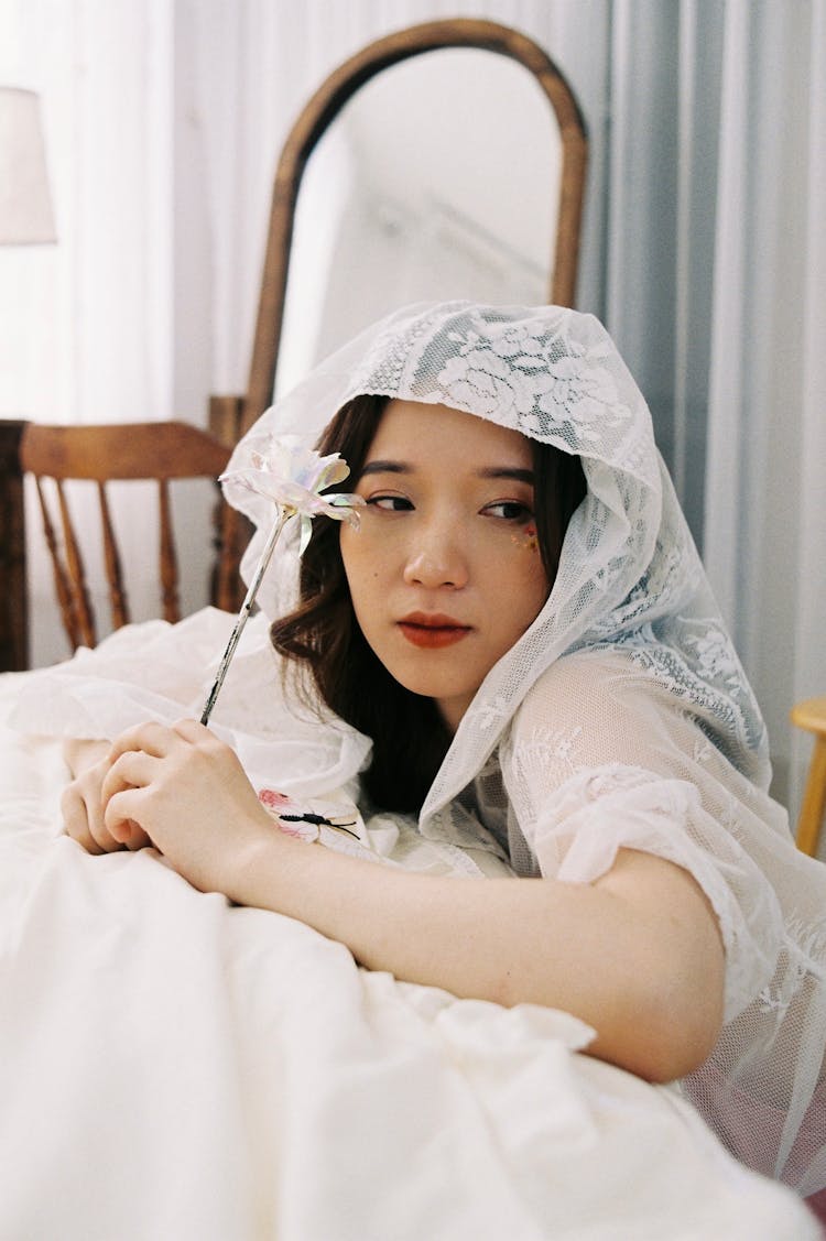 Brunette Woman In White Lace Kerchief Kneeling At Bed