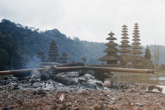 巴厘岛的优美风景中，烧焦的木材背后是传统的佛塔和山脉