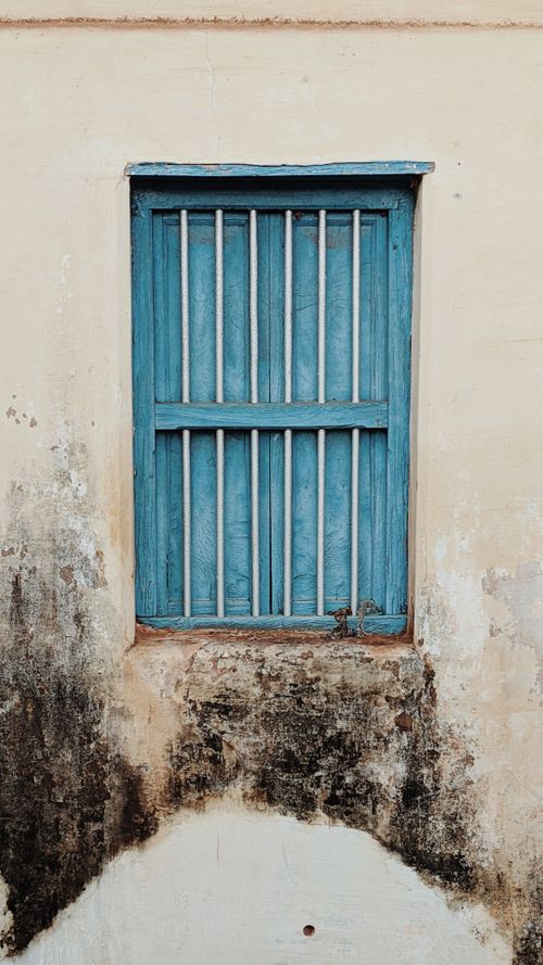 Free A rustic blue shuttered window on a weathered, textured wall. Perfect for architectural themes. Stock Photo