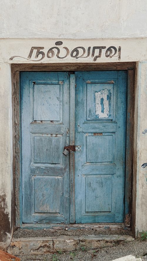 Free Rustic blue wooden door with Tamil script above, evoking nostalgia and cultural heritage. Stock Photo