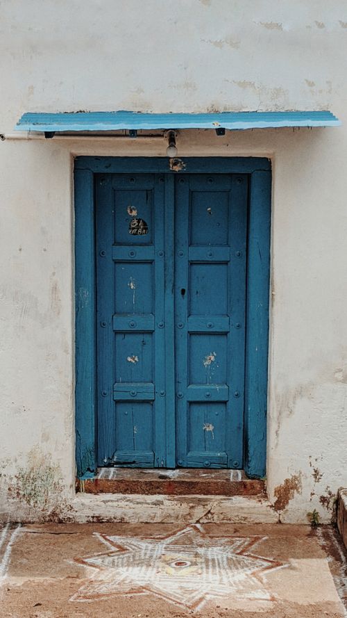 Free A vintage wooden blue door with a geometric star pattern on the ground, perfect for design inspiration. Stock Photo