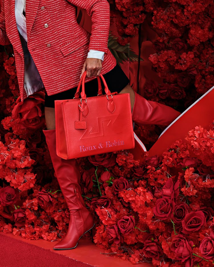 Unrecognizable Woman In Red Coming Out From Behind Pile Of Red Roses