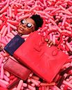 Face of Woman Immersed in Pool of Pink and Red Sausage Balloons