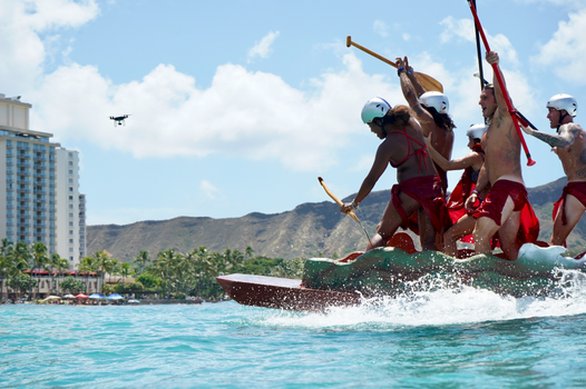 A dynamic canoe race under sunny skies near Honolulu's iconic Diamond Head, capturing summer fun.