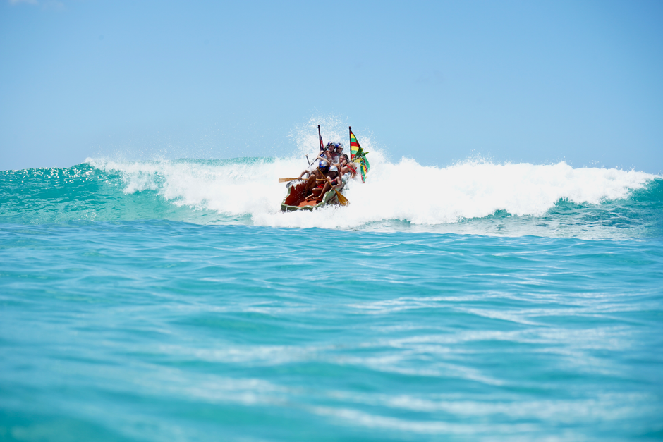 Group enjoying canoeing on vibrant ocean waves in Honolulu, Hawaii.