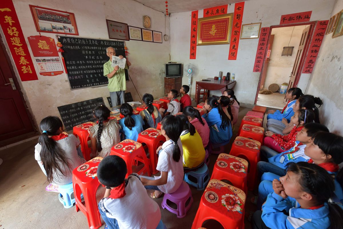 Children attentively listening to teacher in rural classroom in Jiangxi China