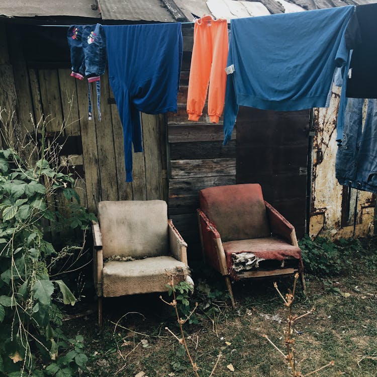 Hanging Clothes In Front Of A Wooden Old House