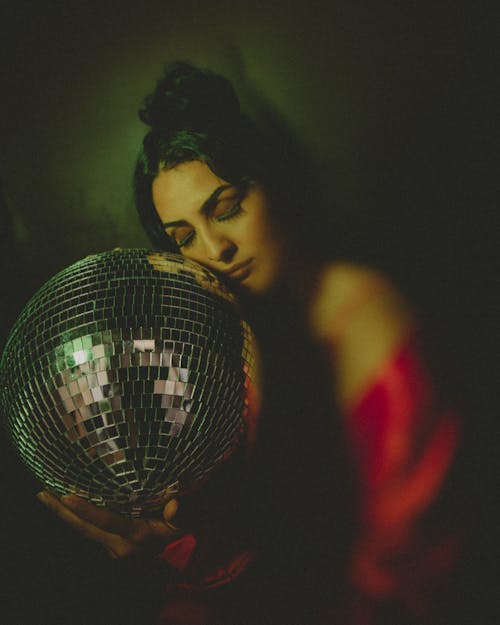 A Woman Holding a Silver Disco Ball