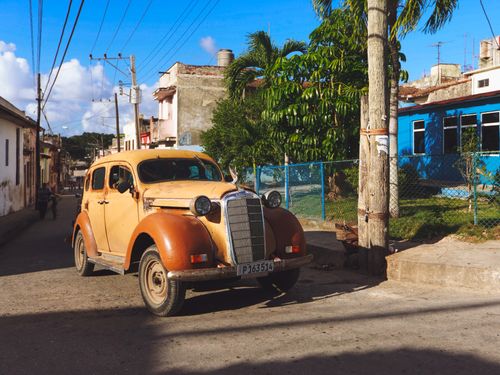Free Classic old car parked on a sunlit street, showcasing vintage transportation in an urban setting. Stock Photo