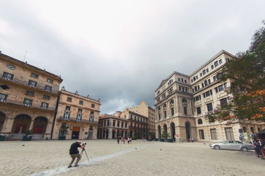 Wide-angle view of Havana's Lonja del Comercio and surrounding architecture with a photographer.