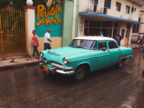 Green and White Vintage Car on the Road