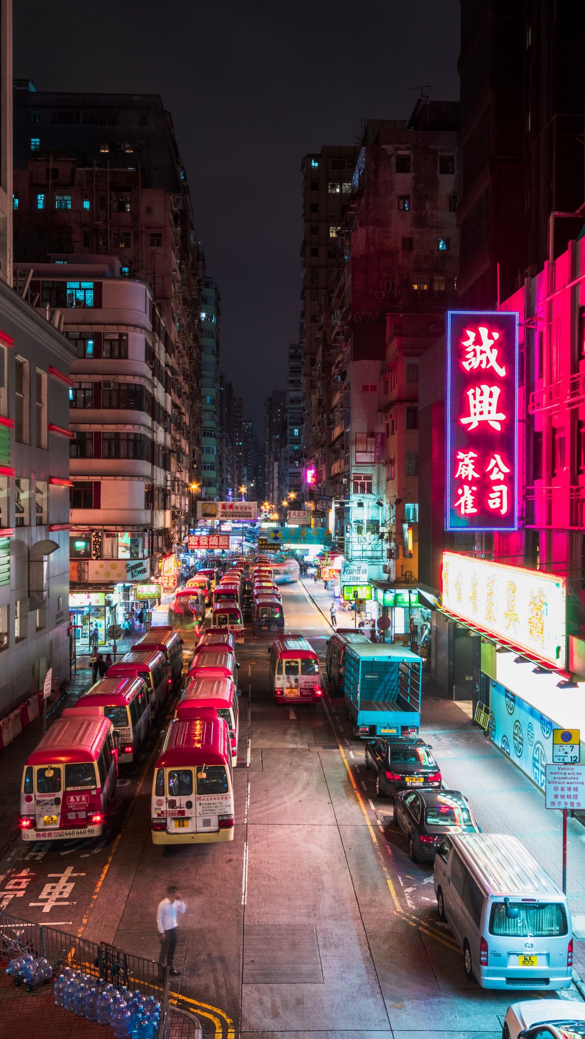Hong Kong street illuminated at night with neon signs and traffic