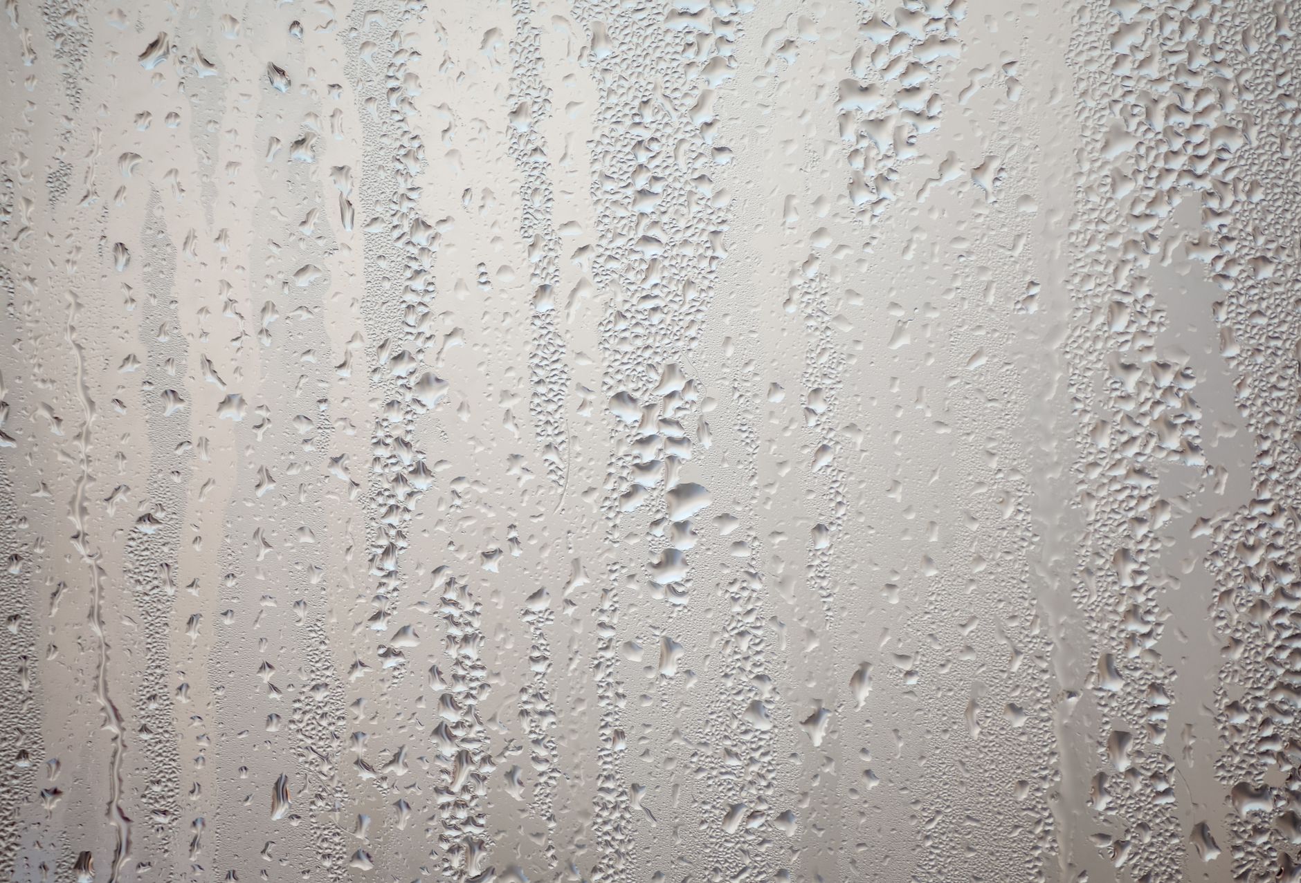 Detailed view of water droplets creating patterns on glass surface.
