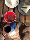 Person Holding Red Ceramic Mug With Black Liquid