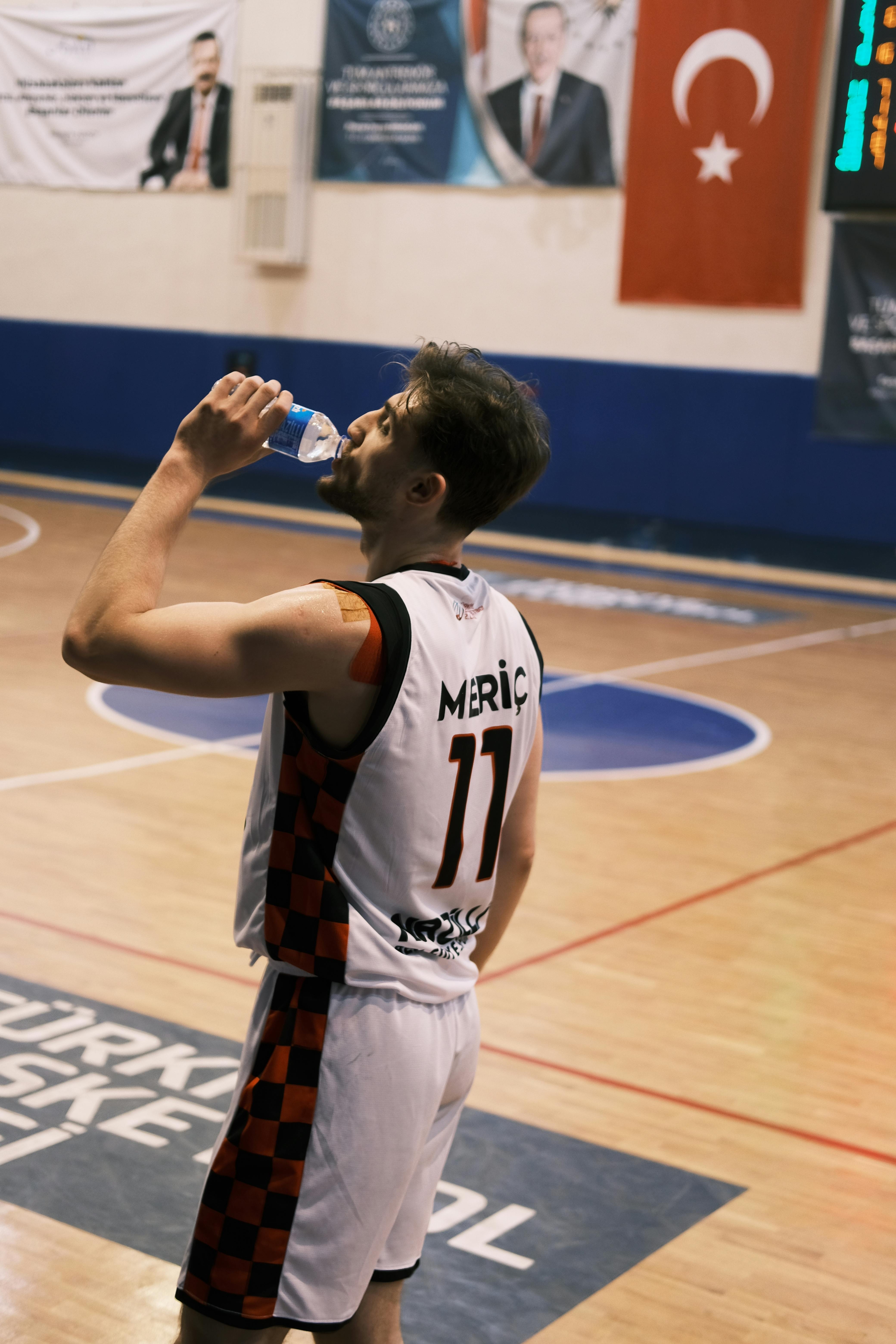 Athlete pausing for hydration during a basketball game in Nazilli, Turkey.
