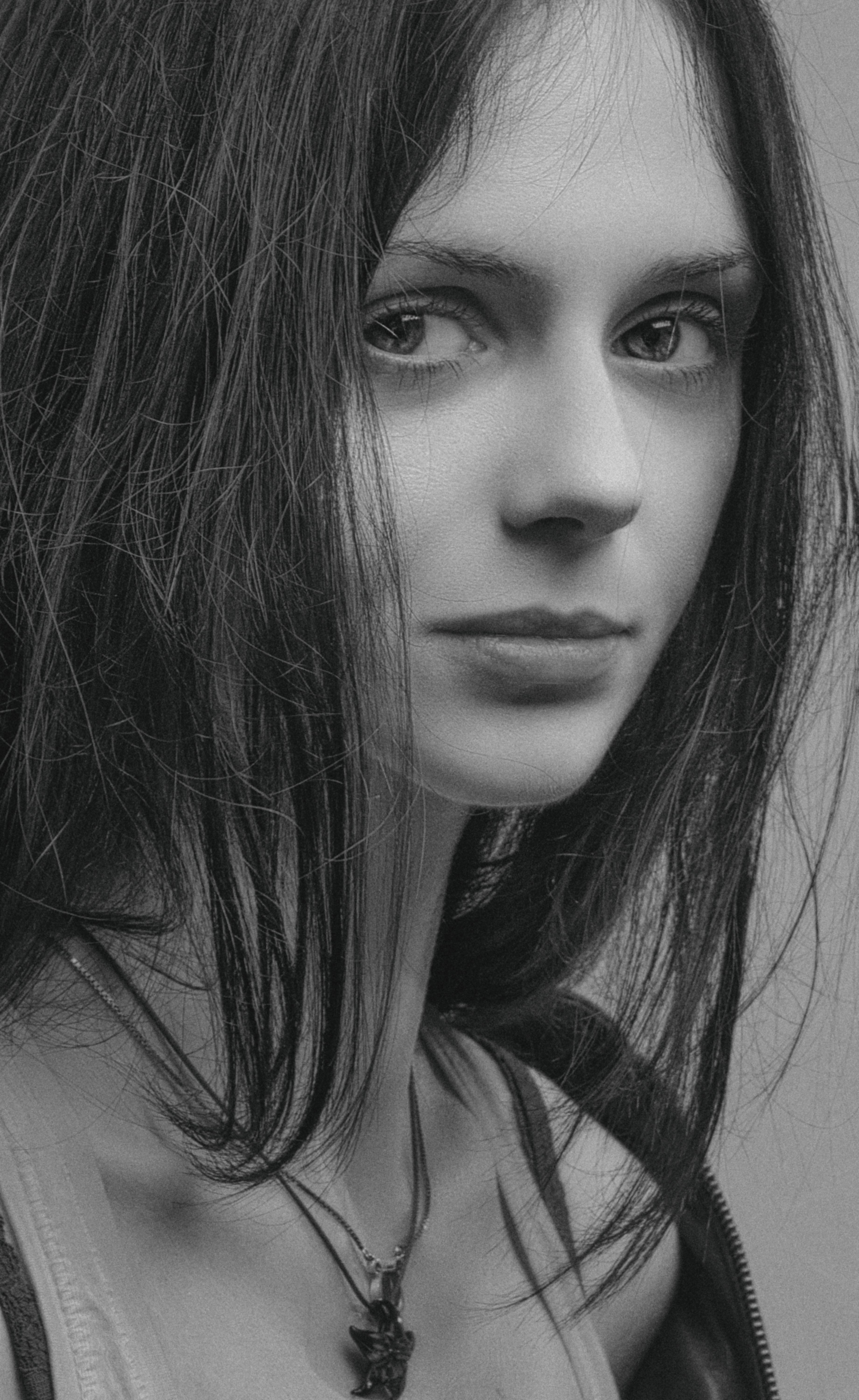 Grayscale portrait of a young woman with intense expression and loose hair.
