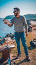 Man in Gray Sweater and Blue Denim Jeans Holding Fishing Rod