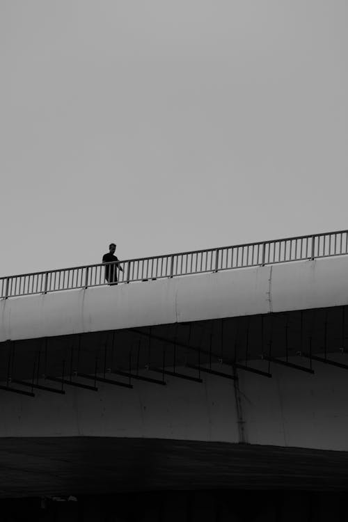 Person Walking on Concrete Bridge
