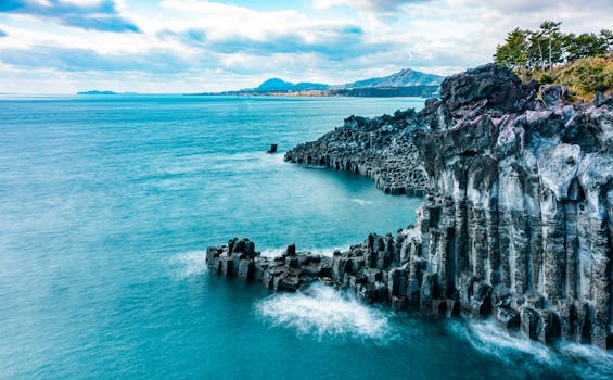 A breathtaking view of Jeju's volcanic cliffs with turquoise waters and dramatic scenery.