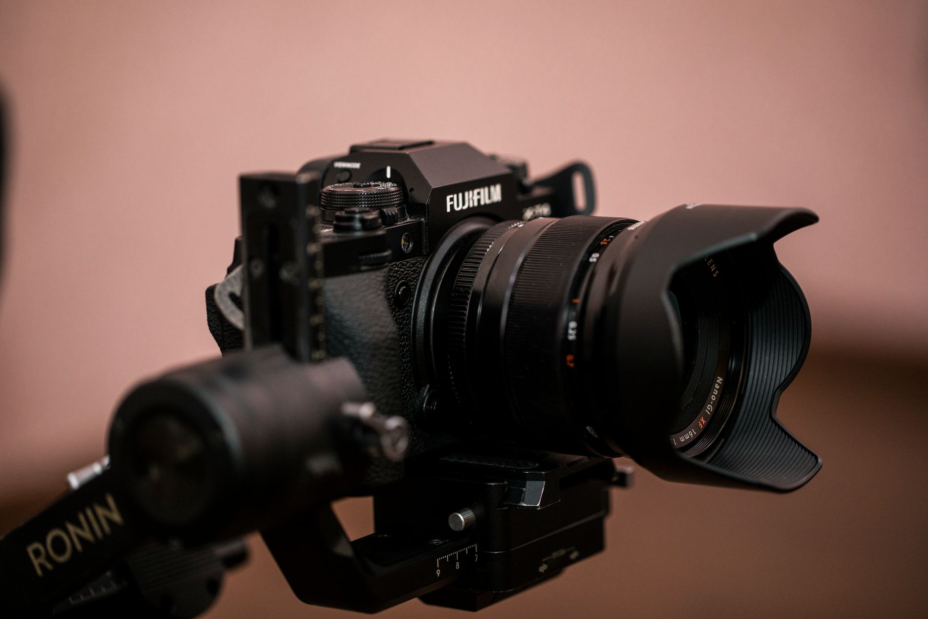 Close-up of a Fujifilm camera mounted on a Ronin gimbal, showcasing photography gear.
