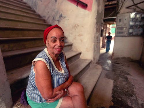 Woman in Headwrap Sitting on Concrete Stairs