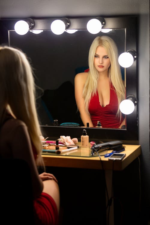 Beautiful Woman Sitting in front of a Mirror in a Dressing Room 