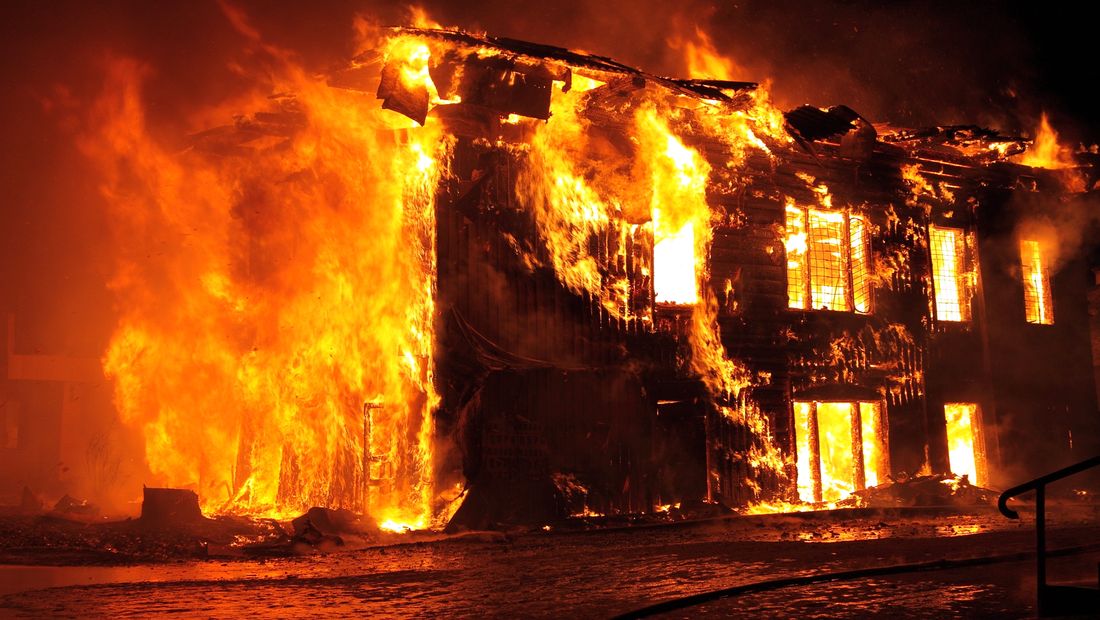 A house engulfed in flames at night — the catastrophic real-world danger of defective Amazon-sold fire pits