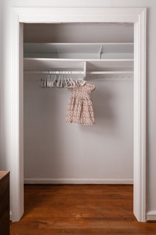 De Jurk Van Een Babymeisje Hangt In Een Lege Kast