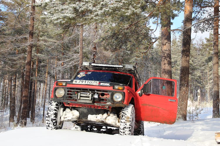 Red 4x4 Driving On Snow In The Forest