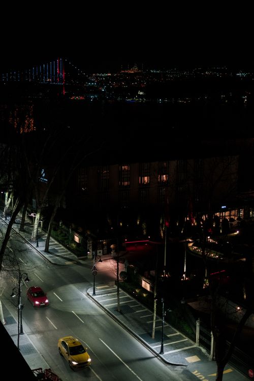 Free Aerial night view of Istanbul featuring illuminated Bosphorus Bridge and vibrant city lights. Stock Photo