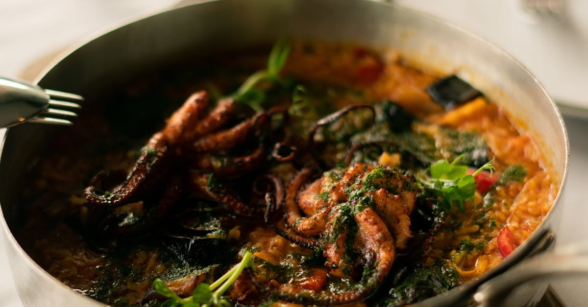 A close-up photo of a colorful and delicious seafood paella dish in a traditional Spanish pan, showcasing shrimp, mussels, and clams mixed with rice and vegetables.