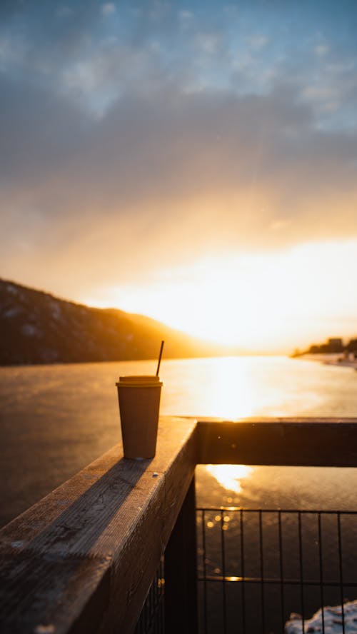 A Cup of Coffee on a Railing during the Golden Hour