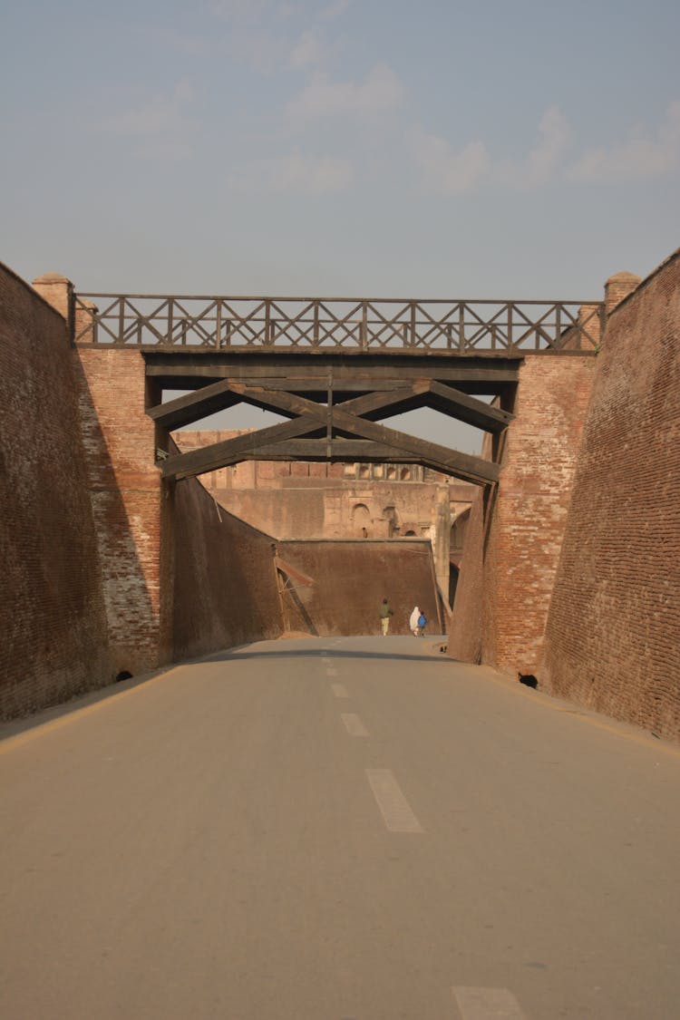 Road Between Brick Walls Connected By Bridge