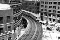 在引人注目的城市场景中，火车沿着被建筑包围的曲线轨道行驶