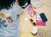 girl laying on a picnic blanket with books and sunglass