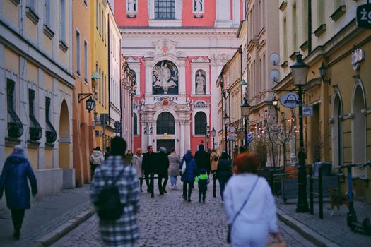 Charming view of a cobblestone street in Poznań leading to St. Stanislaus Church.