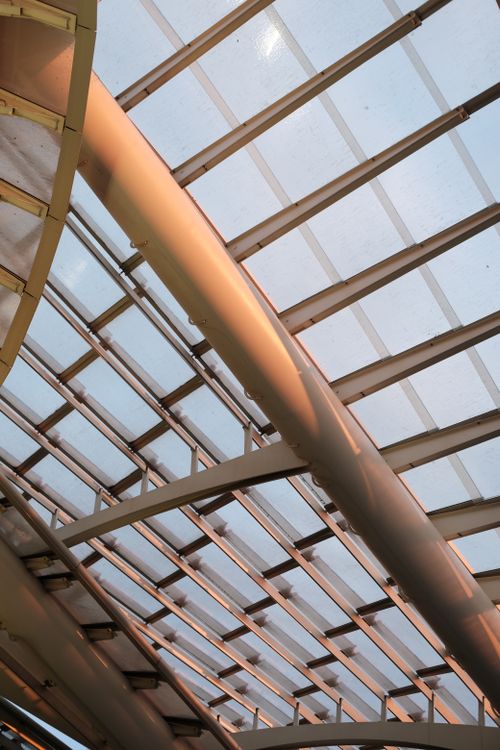 Free Close-up view of a modern architectural glass roof with metal frames under soft lighting. Stock Photo