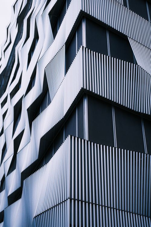 Free Close-up of a modern building with a unique wavy facade and sleek design elements, ideal for urban architecture themes. Stock Photo