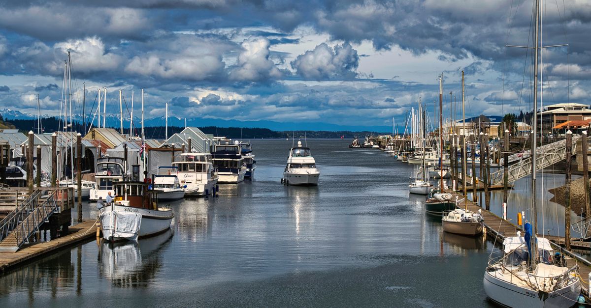 Picturesque marina in Olympia, WA with sailboats and cloudy skies, perfect for travel enthusiasts.