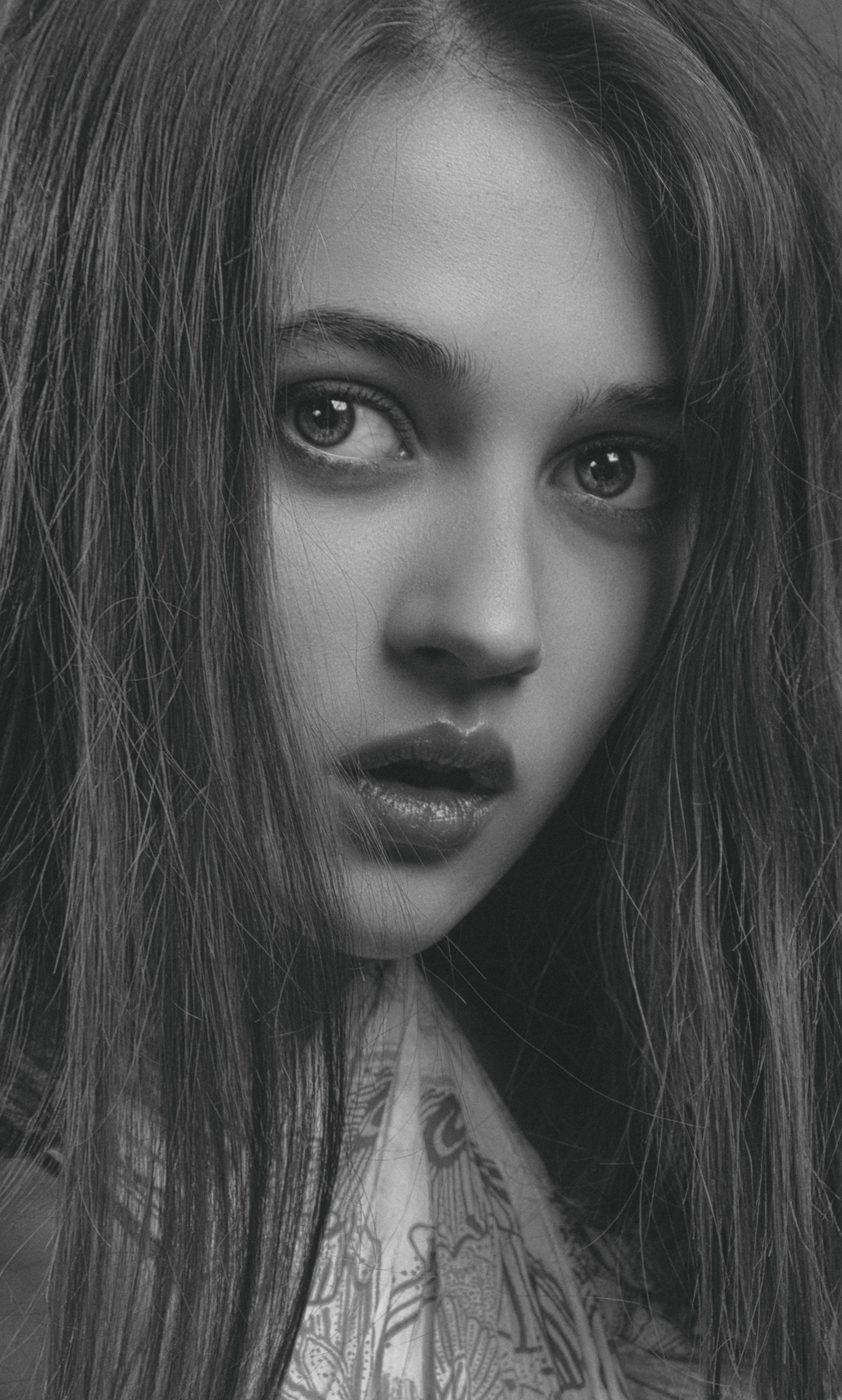 Captivating black and white portrait of a young woman in an expressive close-up.