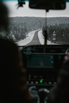 Capture the essence of winter travel with this scenic road view through a snowy forest.
