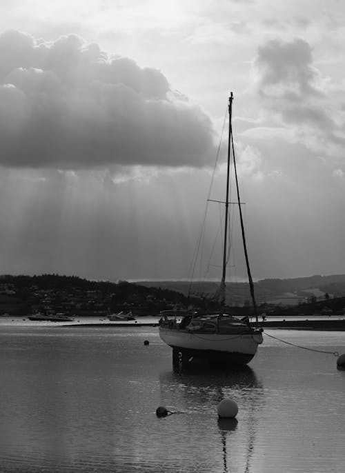 A Grayscale Photo of a Sailboat on the Sea