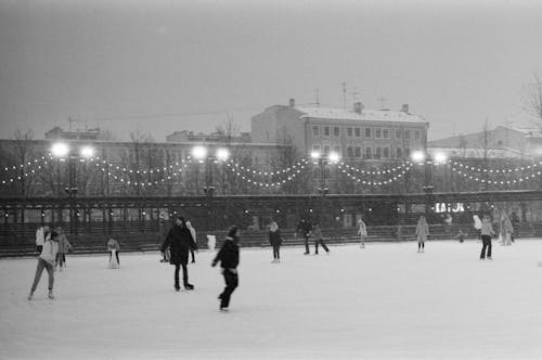 Black and White Photo of People Ice Skating