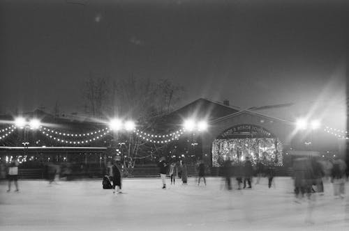 Grayscale Photo of People Ice Skating