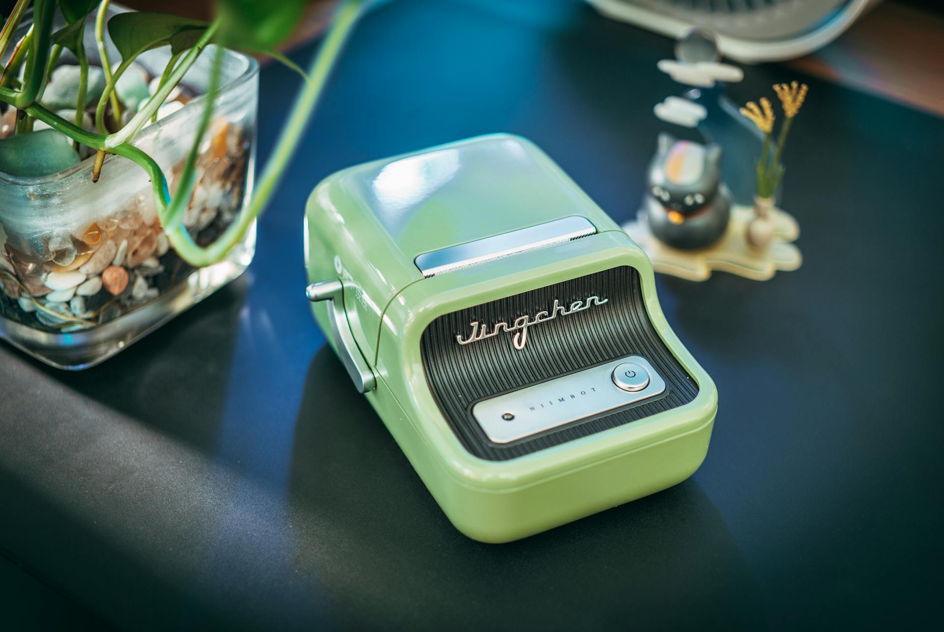 Retro-style green label printer on a desk with decorative elements capturing a vintage vibe.