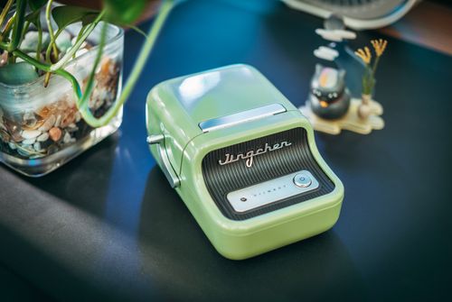 Free Retro-style green label printer on a desk with decorative elements capturing a vintage vibe. Stock Photo